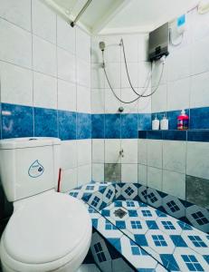 a bathroom with a white toilet and a blue and white tiles at Casa Jessica 329 Dubai style One bedroom Corner unit plus loft in Bacoor