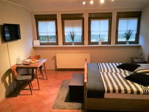 um quarto com uma cama, uma mesa e uma sala de jantar em Landhaus am Brubbel em Wallenborn