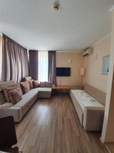 ein Wohnzimmer mit einem Sofa und einem TV in der Unterkunft Apartment with Sea View in Obzor Beach in Obsor
