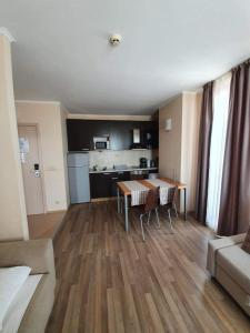 ein Wohnzimmer mit einem Tisch und einer Küche in der Unterkunft Apartment with Sea View in Obzor Beach in Obsor