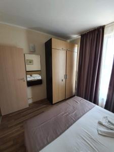a bedroom with a bed and a cabinet and a window at Obzor Beach Resort Exclusive sea view apartment in Obzor