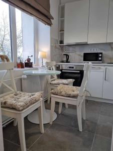 a kitchen with white cabinets and a table and chairs at Old town in Mažeikiai