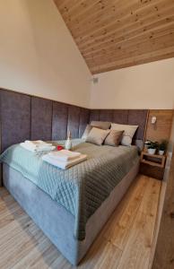 1 cama grande en un dormitorio con techo de madera en Nowe Domki Deluxe z widokiem na zatokę z basenem i sauną en Osłonino
