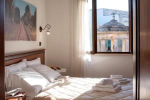 1 dormitorio con 1 cama con toallas en Relais Casina Copini, en Spongano