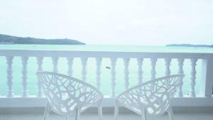 dwa krzesła siedzące na balkonie z widokiem na ocean w obiekcie Salt life Port Blair w mieście Port Blair