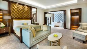 ein Schlafzimmer mit einem Bett, einem Sofa und einem Stuhl in der Unterkunft The Ritz-Carlton, Dubai in Dubai