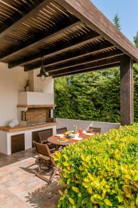 イアリソスにあるFilerimos Oasis Villaの木製パーゴラとテーブル付きのパティオ