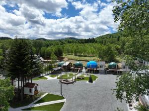 una vista aérea de un parque con tiendas y mesas en Glamping TOMAMU en Tomamu