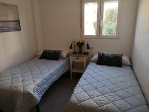 2 camas en una habitación con ventana en Apartamento de diseño con piscina y garaje en Altea