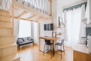 a tiny apartment with a desk and a loft bed at Studio cosy avec mezzanine calme hypercentre Villa Marie Celine in Vichy +15 photos