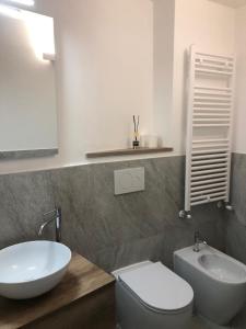 a bathroom with a white sink and a toilet at Porta del centro in Gubbio