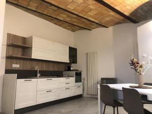 a kitchen with white cabinets and a table with chairs at Porta del centro in Gubbio