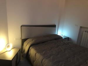 a bedroom with a bed and two night stands with lights at Porta del centro in Gubbio