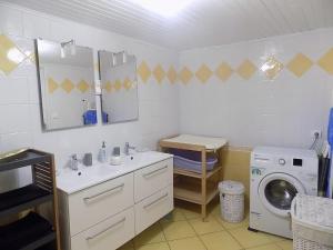 a bathroom with a sink and a washing machine at gite le peuplier in Boisset