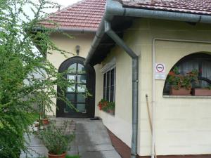une maison avec une porte et des plantes en pot dans l'établissement Szilvió, à Gyenesdiás