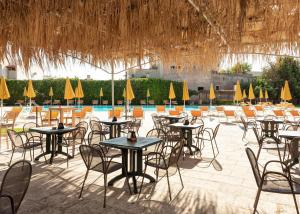 um grupo de mesas e cadeiras em frente a uma piscina em Relais Casina Copini em Spongano