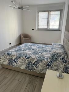 ポルトフェッラーイオにあるSuite del Portoのベッドルーム1室(青と白の掛け布団付きのベッド1台付)