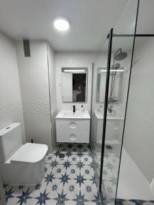 La salle de bains est pourvue de toilettes, d'un lavabo et d'un miroir. dans l'établissement Apartamento Jardines del Rocío, à Torre del Mar