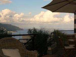 - Balcón con sombrilla y vistas al agua en casagratiaone, en Taormina