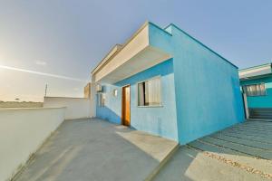 - un bâtiment bleu et blanc avec une porte orange dans l'établissement Casa de veraneio a 2km da praia, à Porto Seguro