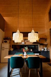 a kitchen with a table with green chairs and chandeliers at Zillya Club in Tatariv