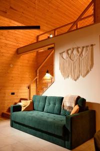 - un canapé vert dans le salon doté de murs en bois dans l'établissement Zillya Club, à Tatariv