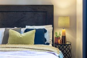 een bed met blauwe en witte kussens en een lamp bij Heritage Luxury Apartment-Footy & CBD in Geelong