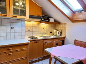 a small kitchen with wooden cabinets and a table at Gästehaus Manfred in Mittenwald +25 photos