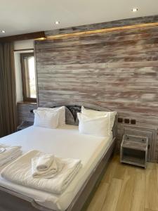 1 dormitorio con 1 cama grande y pared de madera en Guest House Holiday in Melnik, en Melnik