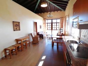 a kitchen and living room with a table and chairs at La Quintana de Villar in Arriondas