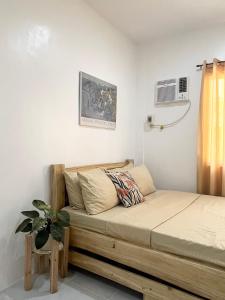 Cette chambre comprend un lit et une plante. dans l'établissement Sunnydale Apartelle -Room Accommodation near Calatagan Beach Resorts, à Batangas City