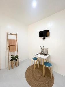 une chambre avec une table, deux chaises et une télévision dans l'établissement Sunnydale Apartelle -Room Accommodation near Calatagan Beach Resorts, à Batangas City