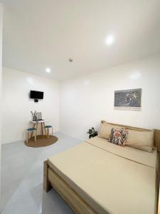 a bedroom with a bed and a table at Sunnydale Apartelle -Room Accommodation near Calatagan Beach Resorts in Batangas City