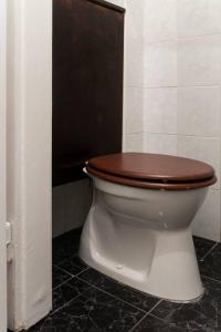 a toilet with a wooden seat in a bathroom at Central Buda Comfort in Budapest