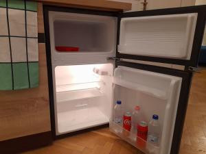 um frigorífico aberto com a porta aberta e bebidas no interior em Central Buda Comfort em Budapeste