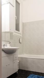 a white bathroom with a sink and a tub at Central Buda Comfort in Budapest