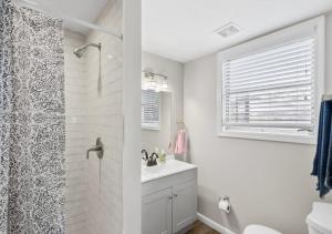 uma casa de banho branca com um chuveiro e um lavatório. em Perfect 2 Bd 1BA In Jacksonville em Jacksonville