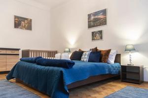 a bedroom with a bed with a blue comforter at Central Buda Comfort in Budapest