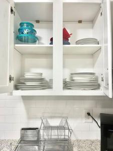 a kitchen cabinet with plates and dishes in it at Memorable and Enjoyable Near all the Action in Athens in Athens