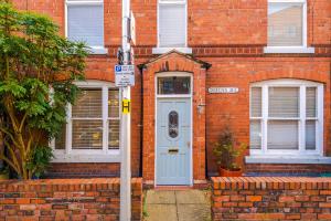 una casa in mattoni con una porta blu e un cartello stradale di Queens Avenue - Central Chester Home - Sleeps 9 a Chester