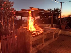 a fire pit in a backyard at sunset at Holiday House Torre Di Manfria in Gela
