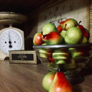 a bowl of apples on a table next to a clock at Bundanoon Bijou Southern Highlands Accommodation in Bundanoon