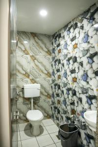 a bathroom with a toilet and a sink at Hotel Aaram Kalupur in Ahmedabad