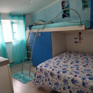 a bedroom with a bunk bed and a ladder at Appartamento da alessandra in Torvaianica