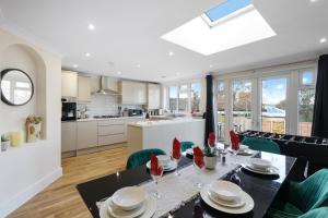 Spacious house in Wembley - Garden في لندن: مطبخ وغرفة طعام مع طاولة وكراسي