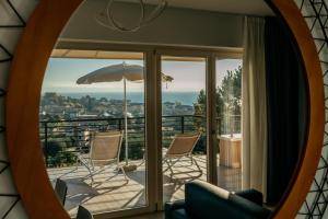 ein Spiegel, der eine Terrasse mit Stühlen und einem Sonnenschirm reflektiert in der Unterkunft Apartments Monsurei, Lake view in Bardolino