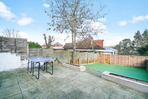 a patio with a table and a tennis court at Spacious house in Wembley - Garden in London