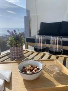 a table with two wine glasses and a bowl of nuts at Luxury duplex with sea views Blue Suite 3-303 in Manilva