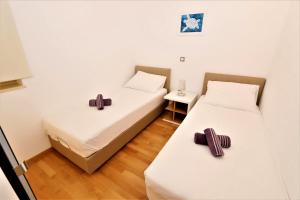 Dos camas en una habitación con cruces sobre ellas. en Cascada Villas, en Novalja 22 fotos más