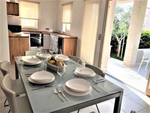 una mesa de comedor con platos y copas de vino en Cascada Villas, en Novalja